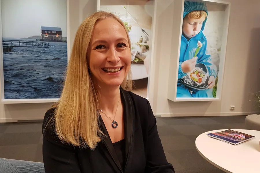 En kvinne som smiler foran et maleri