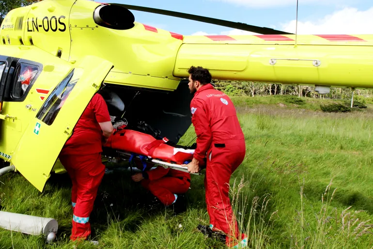 Pasient løftes inni ambulansehelikopter