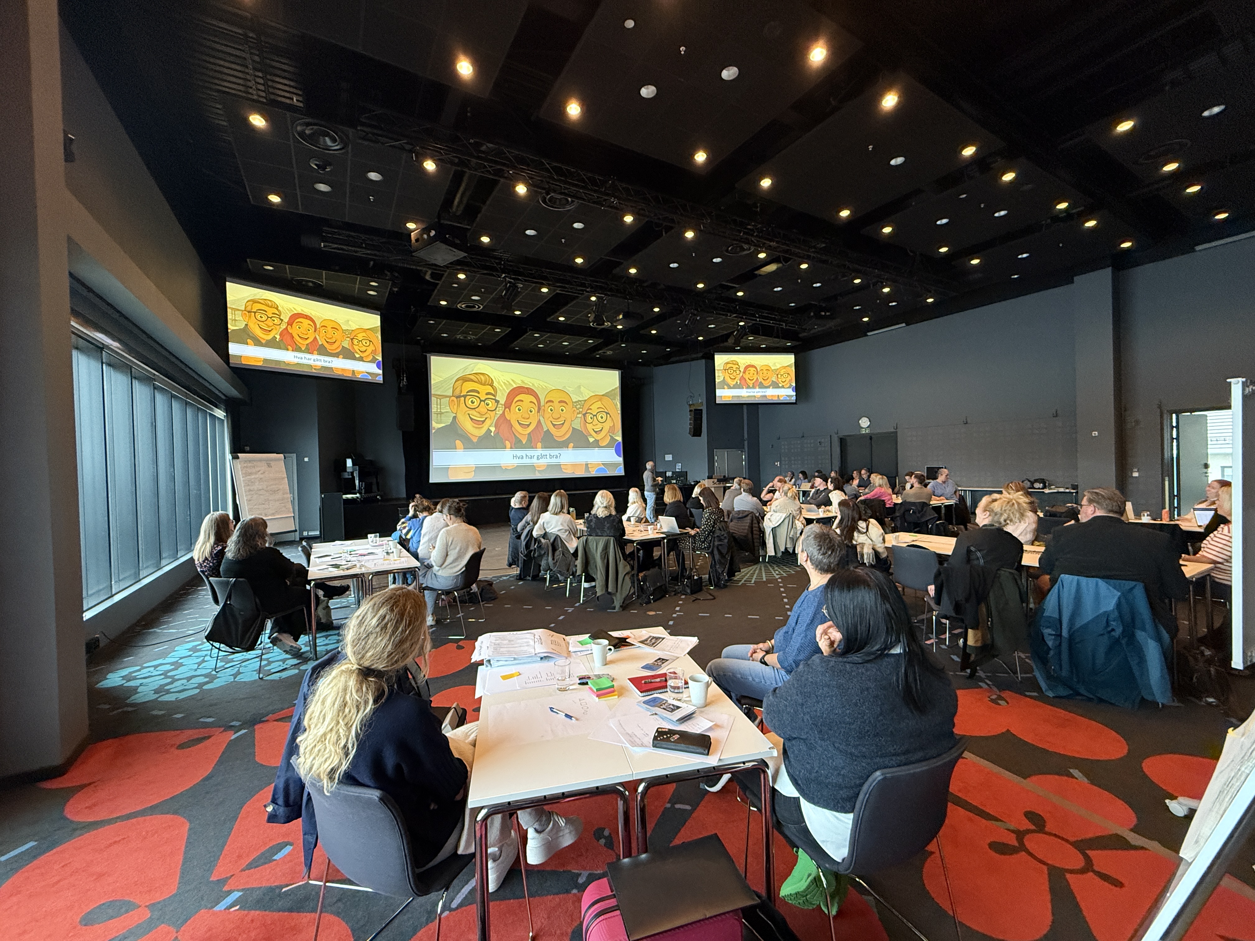 En gruppe mennesker som sitter ved bord