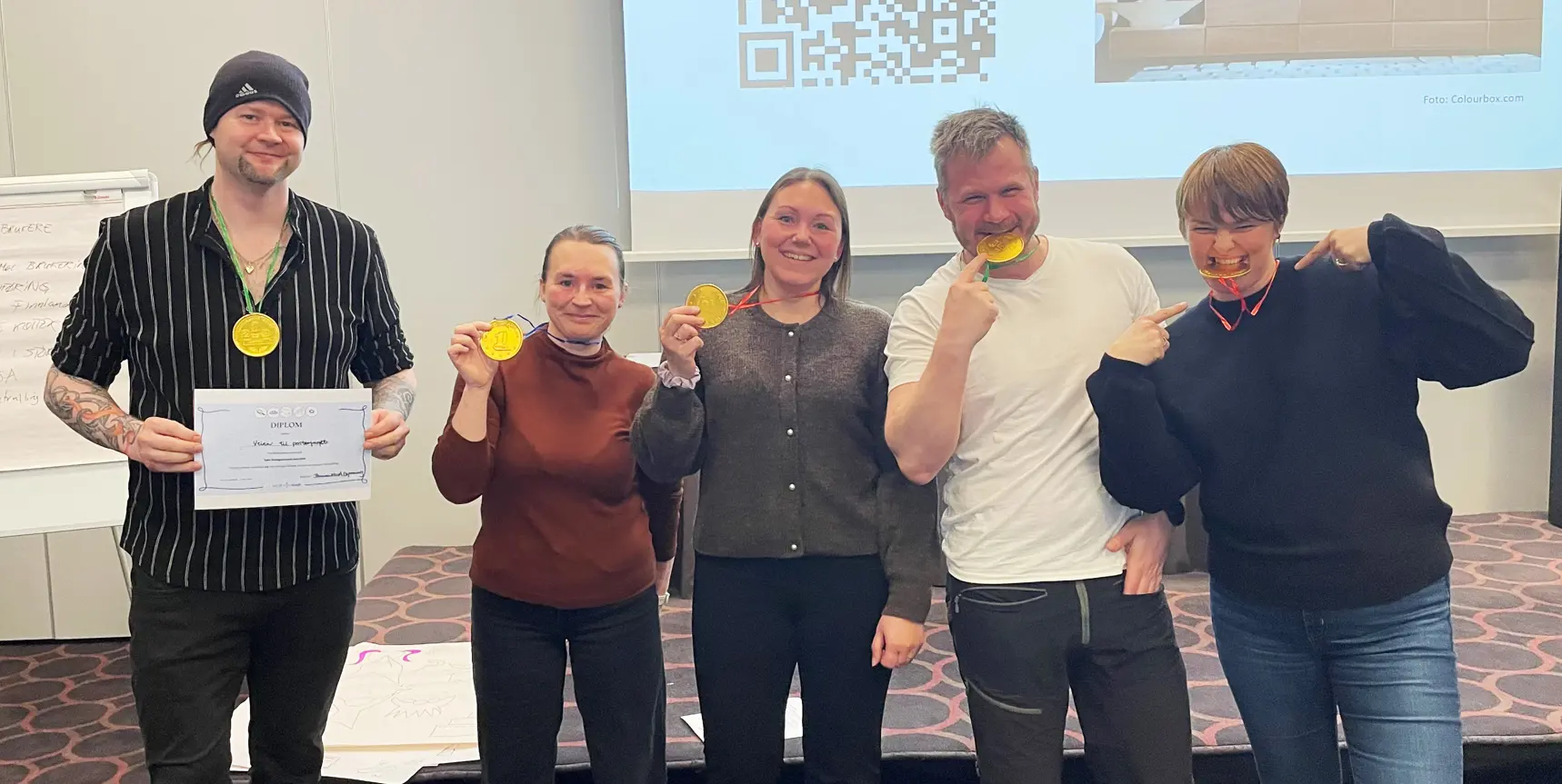 En gruppe mennesker som holder opp medaljer