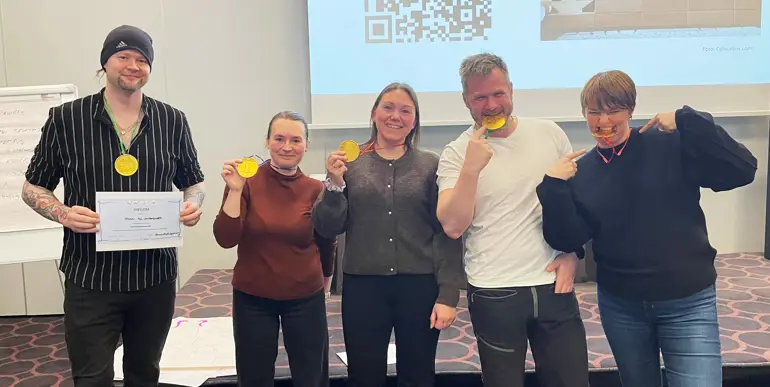 En gruppe mennesker som holder opp medaljer