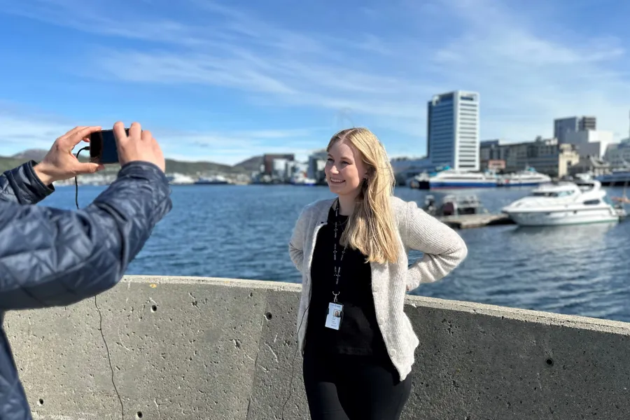 En person som tar et bilde av en person foran en vannmasse