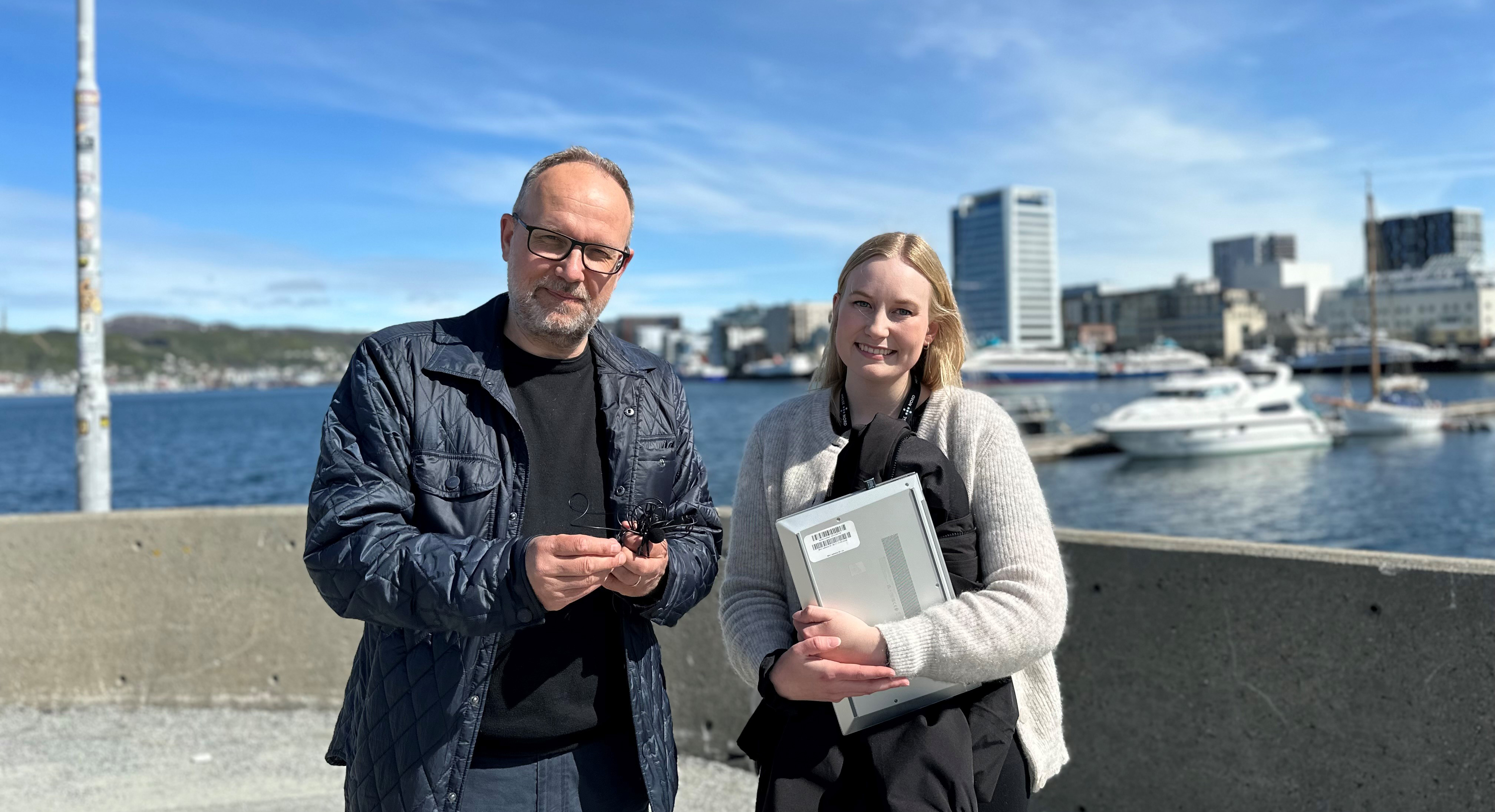 En mann og kvinne som poserer for et bilde med en vannmasse bak seg