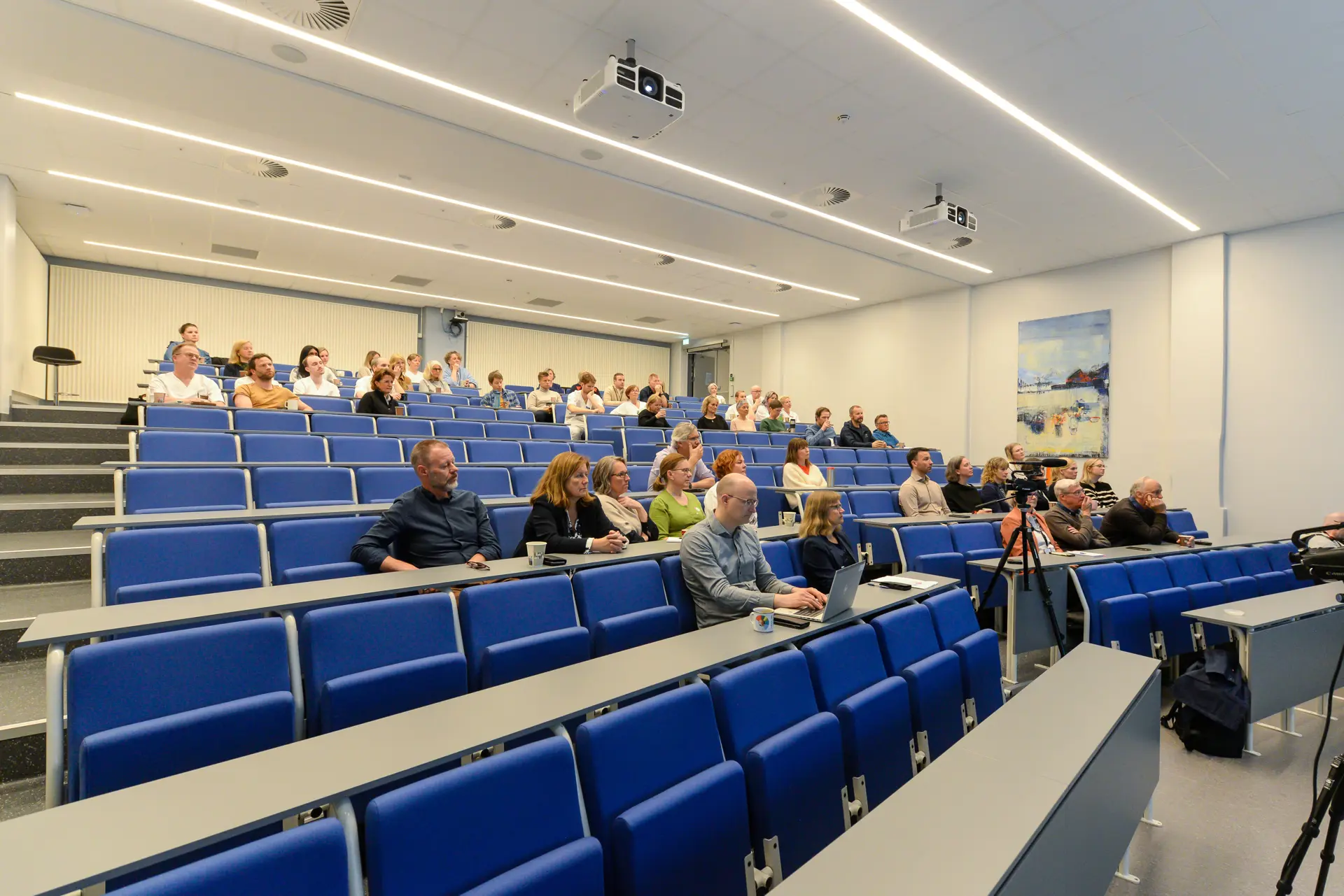 En gruppe mennesker som sitter i et konferanserom