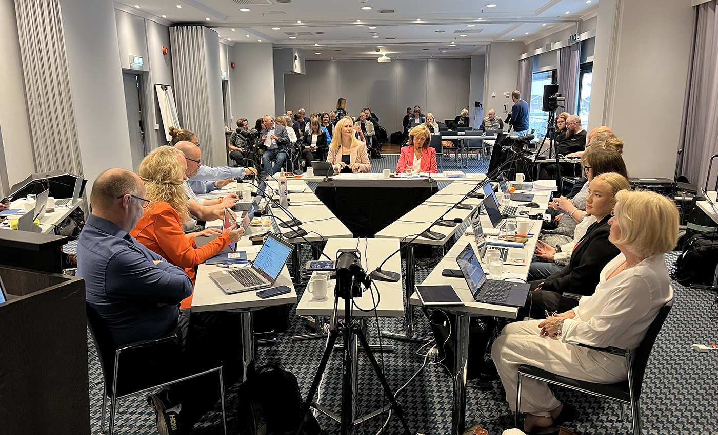 En gruppe mennesker som sitter ved et bord med bærbare datamaskiner