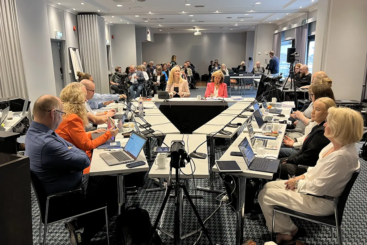 En gruppe mennesker som sitter ved et bord med bærbare datamaskiner