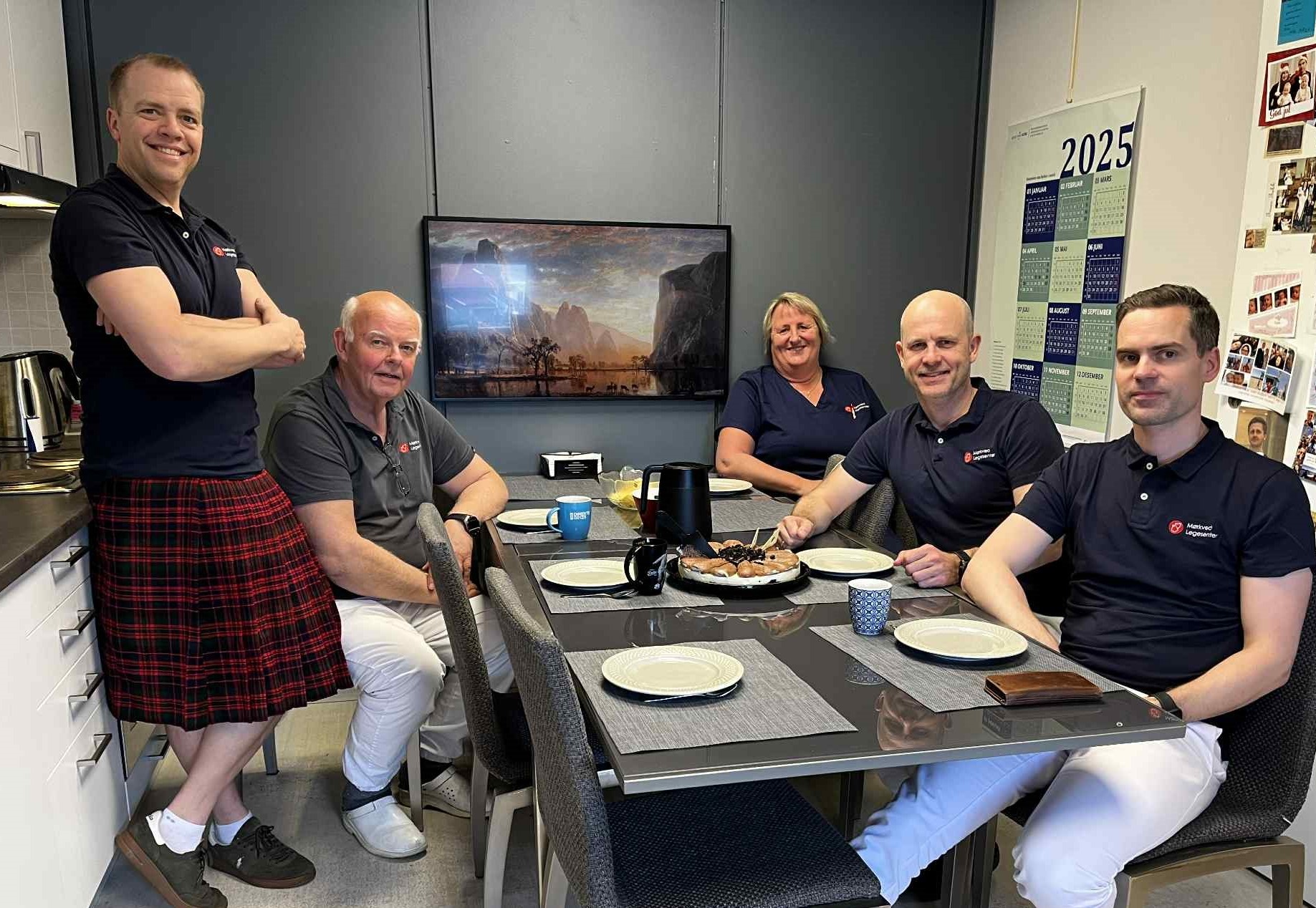 En gruppe mennesker som sitter rundt et bord med mat på