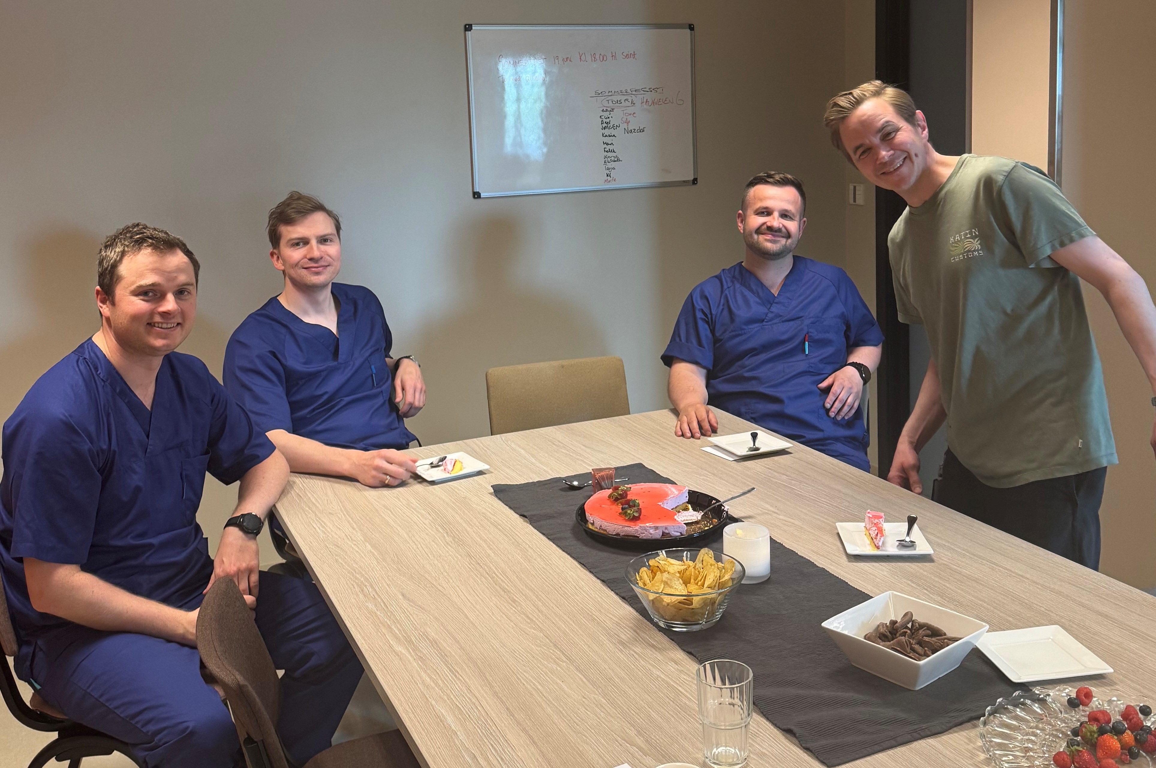 En gruppe menn som sitter rundt et bord med mat på