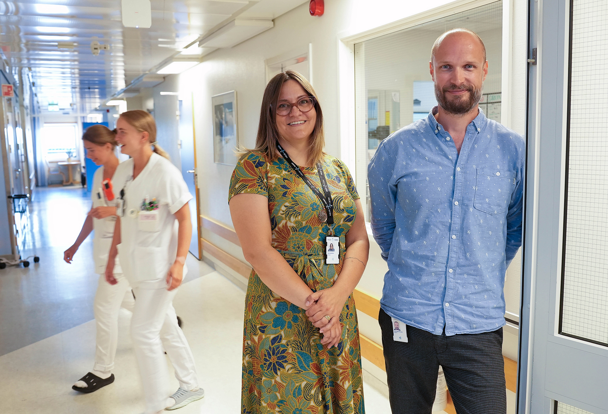 En mann og en kvinne som står i en gang med andre mennesker