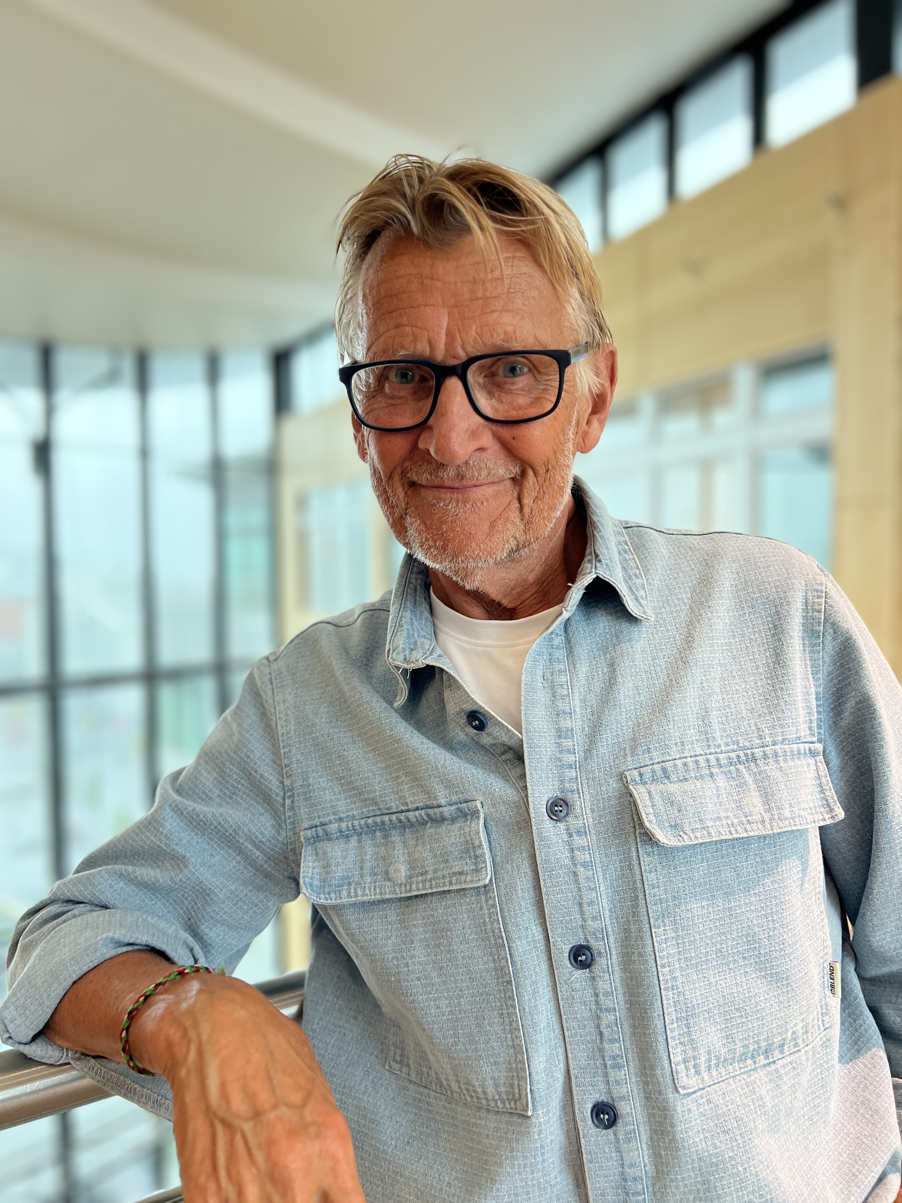 En mann med briller som smiler