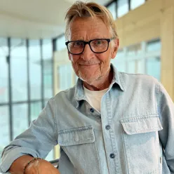 En mann med briller som smiler