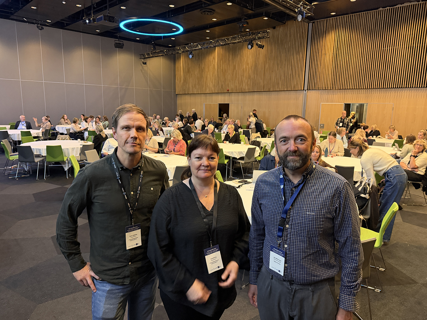 En gruppe mennesker som poserer for et bilde i et rom fullt av bord