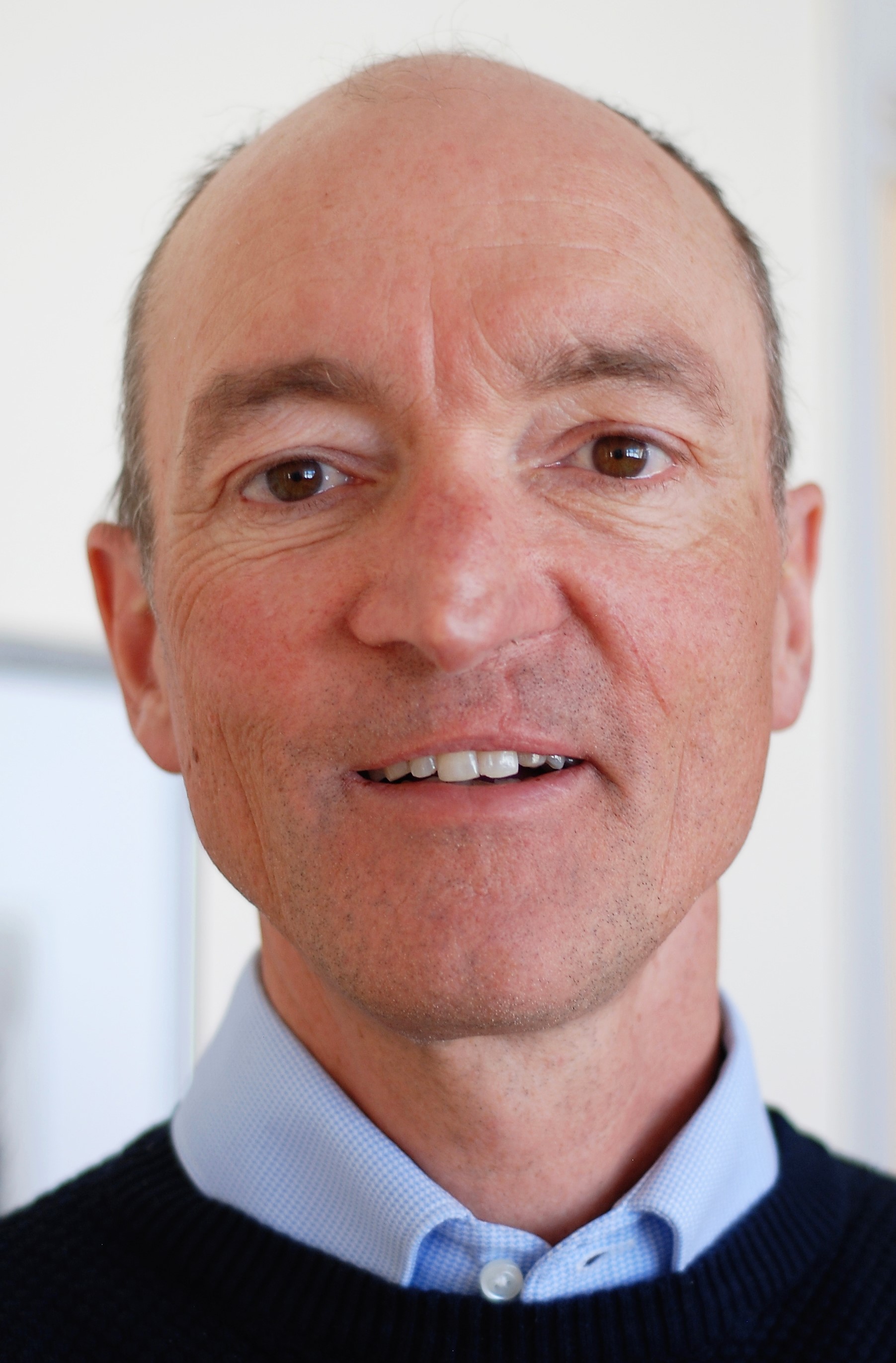 En mann som smiler til kameraet