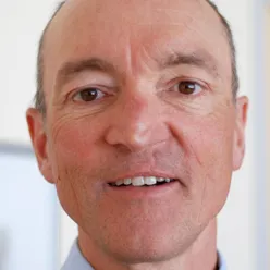 En mann som smiler til kameraet