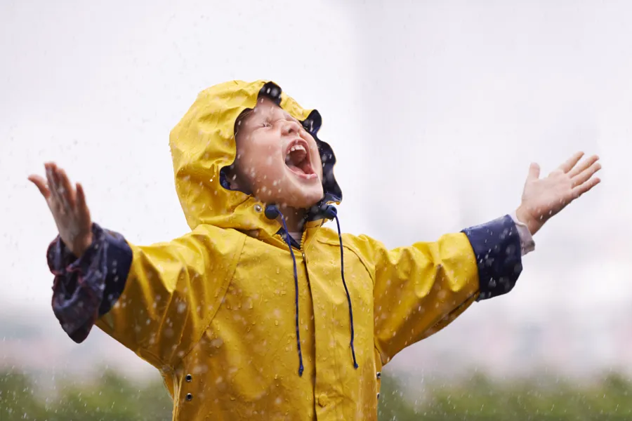 Et barn iført gul regnfrakk