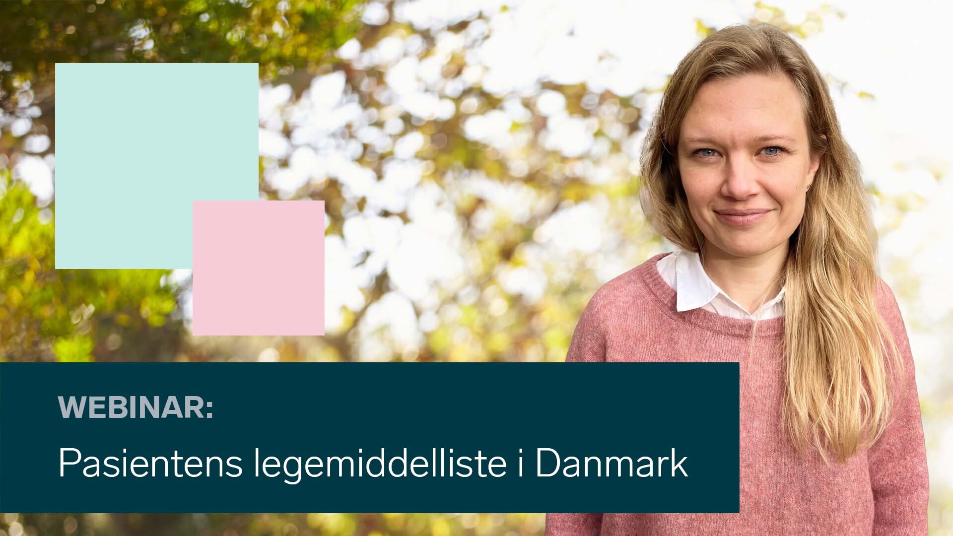 En person som smiler med et skilt bak