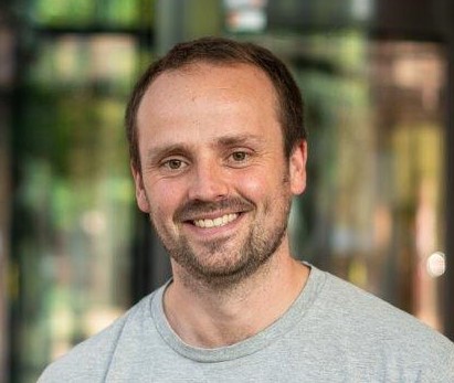 En mann som smiler til kameraet