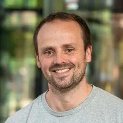 En mann som smiler til kameraet