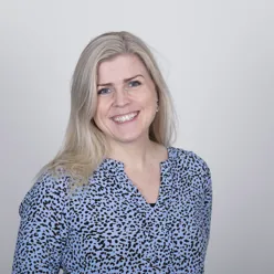 En kvinne som smiler til kameraet