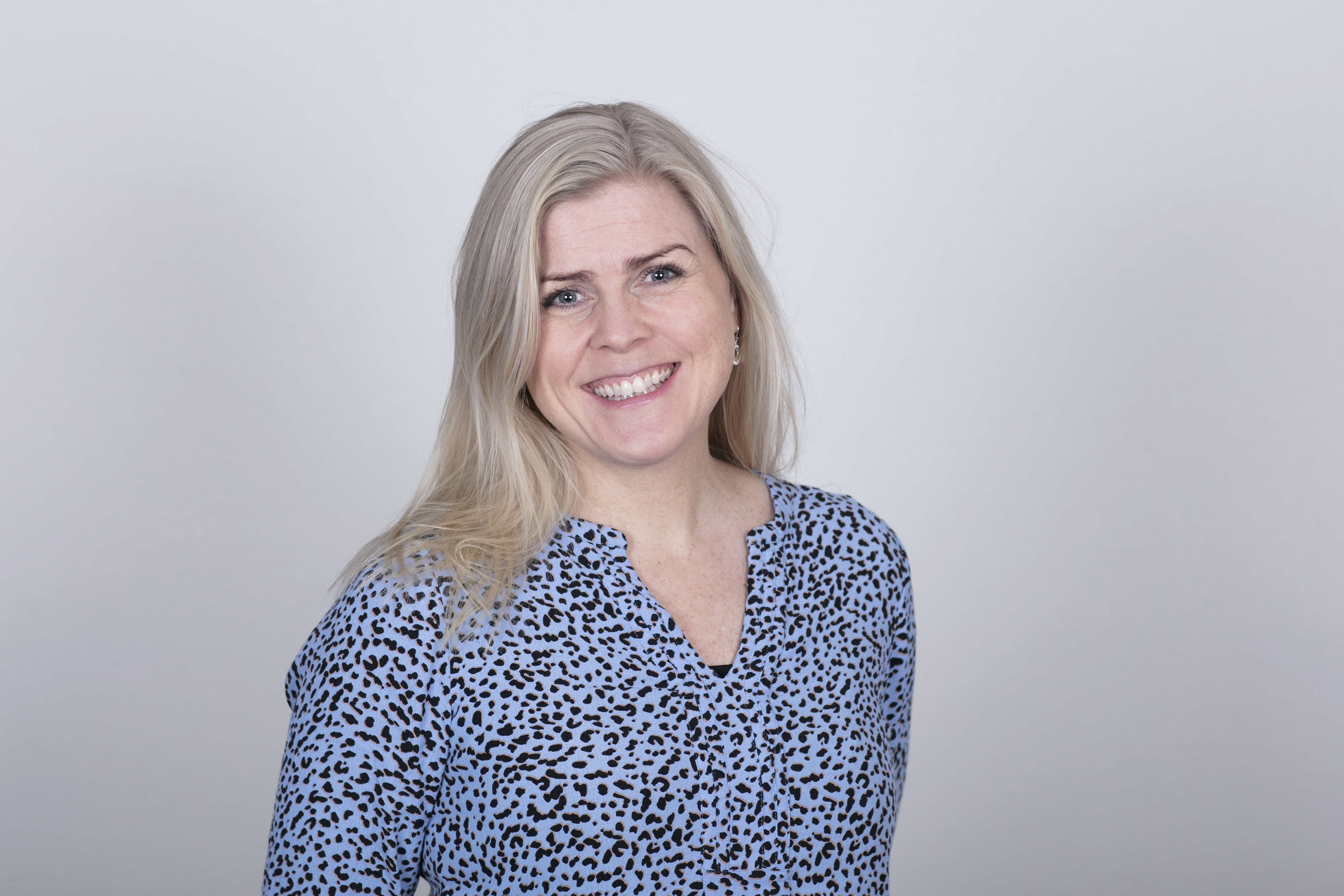 En kvinne som smiler til kameraet