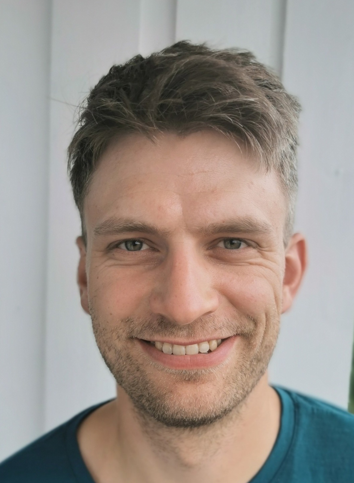 En mann som smiler til kameraet