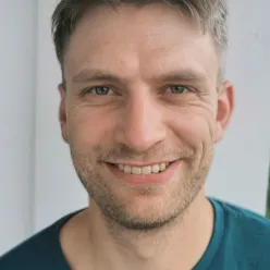 En mann som smiler til kameraet