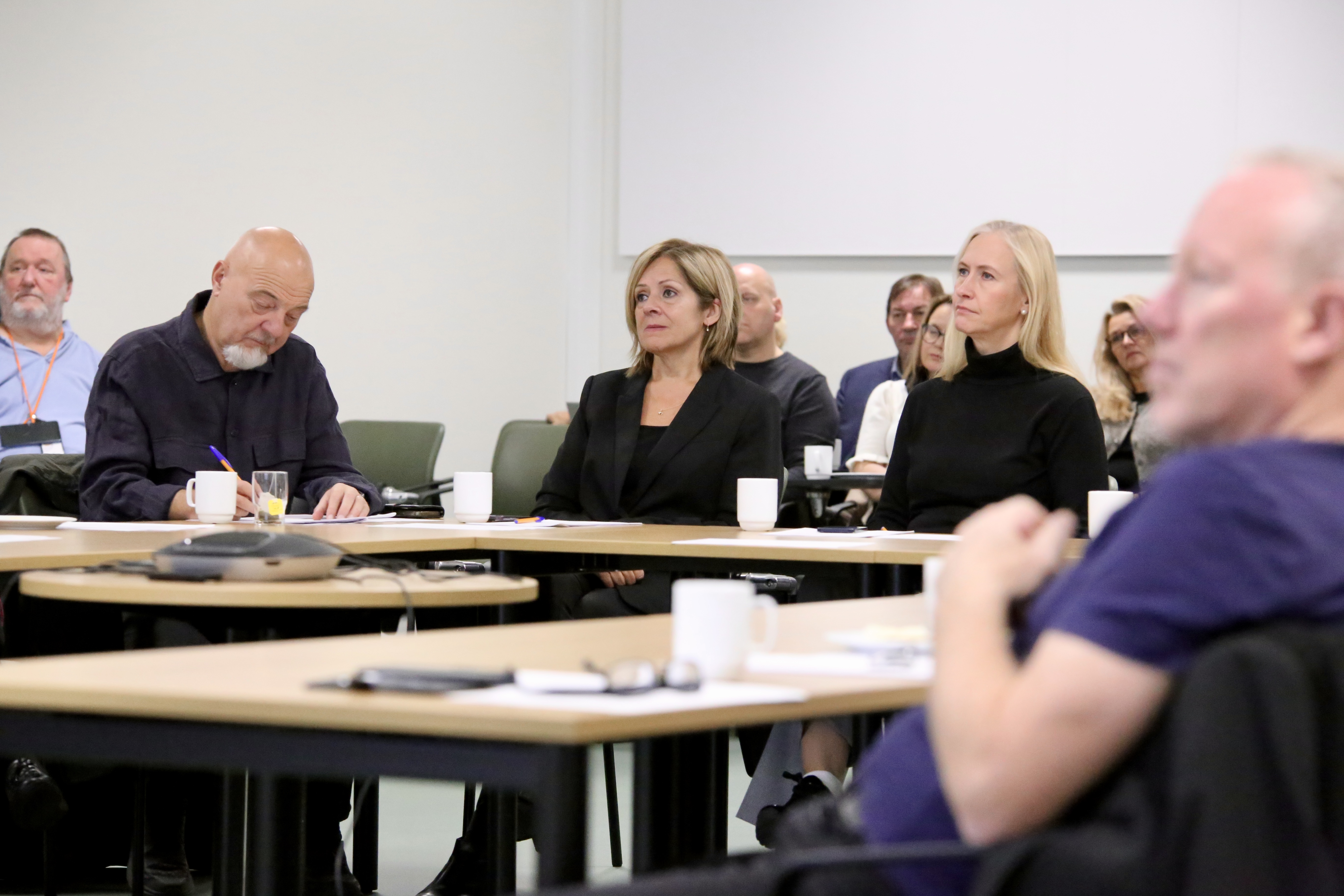 En gruppe mennesker som sitter ved bord