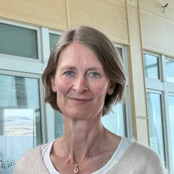 En kvinne som smiler til kameraet