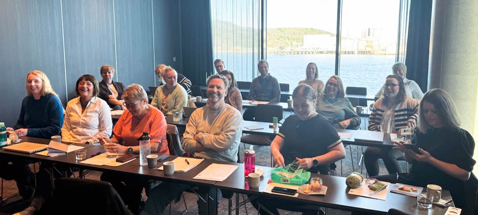 En gruppe mennesker som sitter ved bord