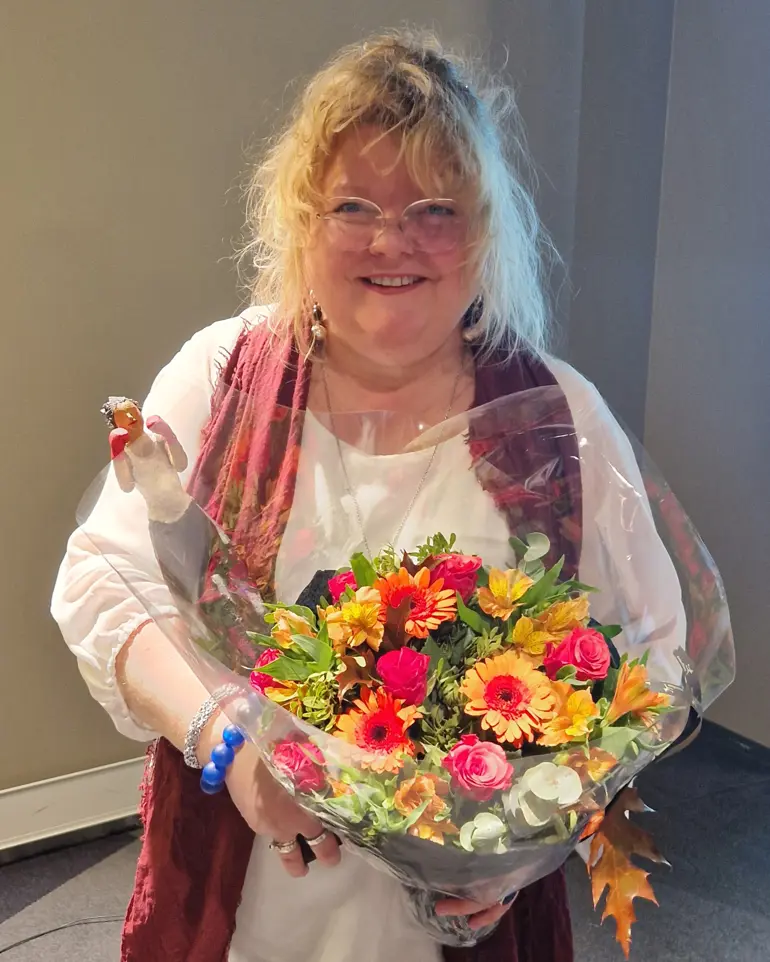 En kvinne som holder en bukett blomster
