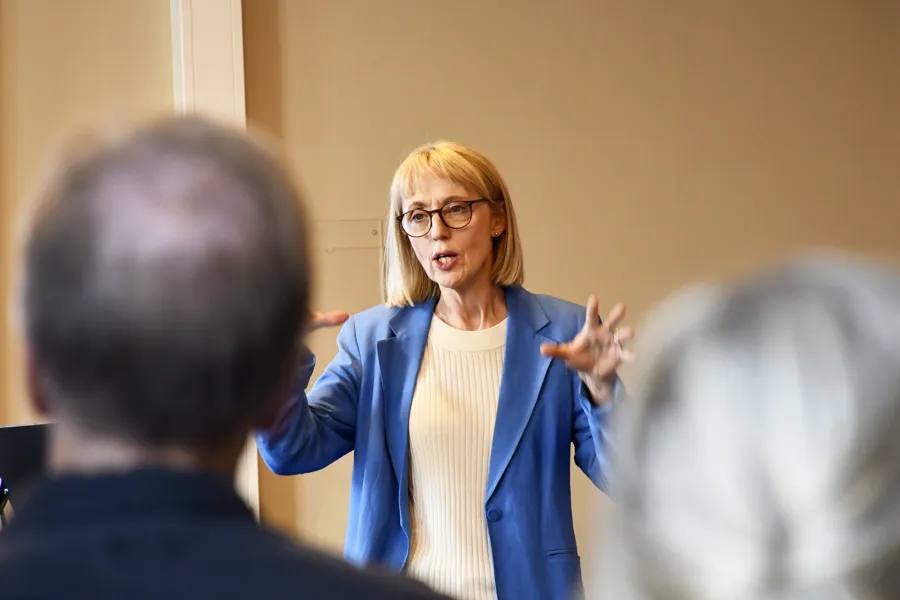 En kvinne i dress som snakker med en mann i dress