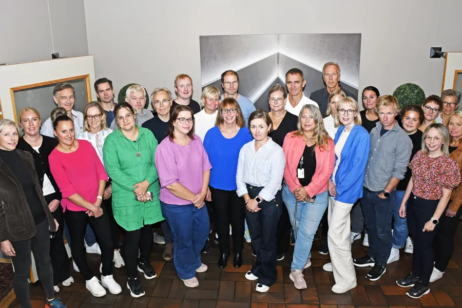 En gruppe mennesker ser i kamera