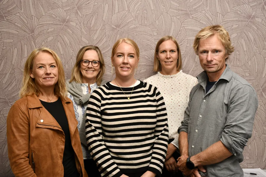 En gruppe mennesker ser i kamera