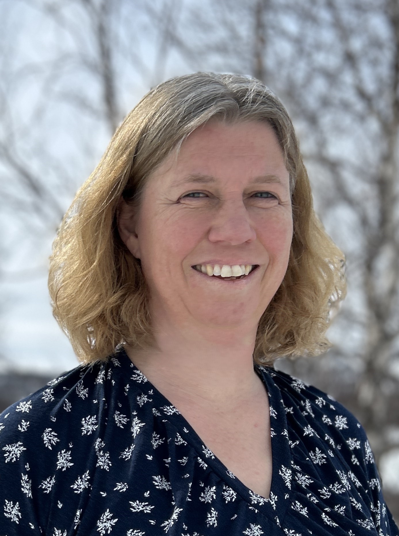 En kvinne som smiler til kameraet