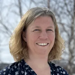 En kvinne som smiler til kameraet