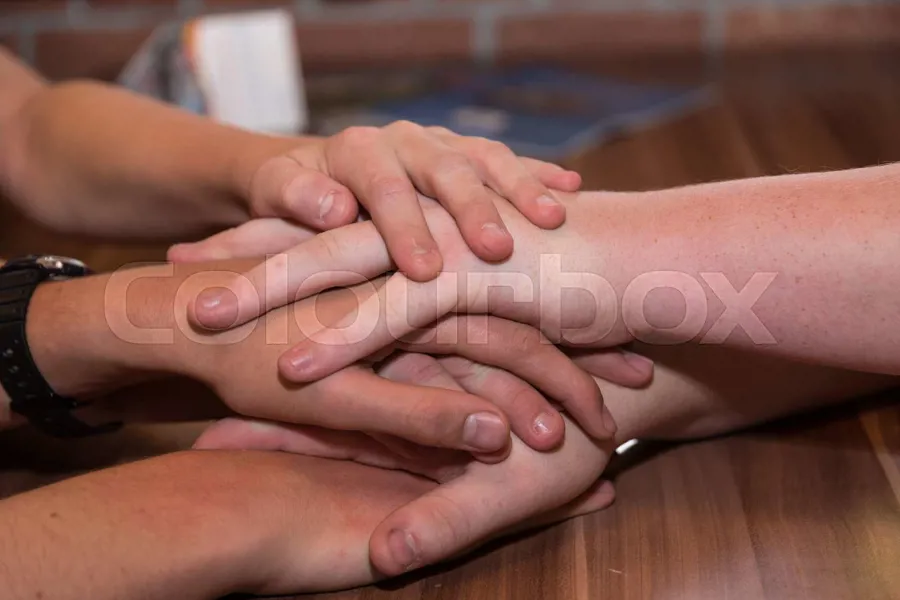 En gruppe hender på et bord
