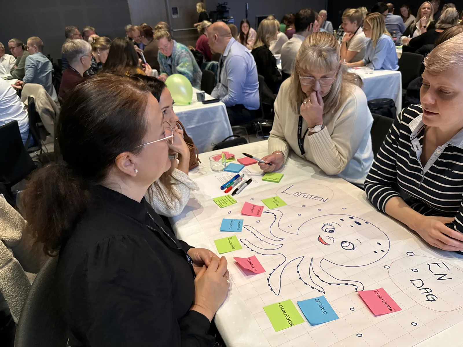 En gruppe mennesker som sitter ved et bord med et brettspill