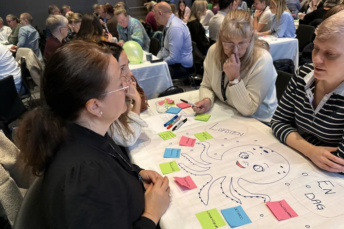 En gruppe mennesker som sitter ved et bord med et brettspill