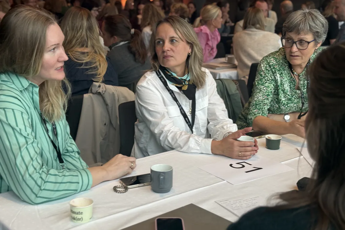 En gruppe kvinner som sitter ved et bord og spiller kort