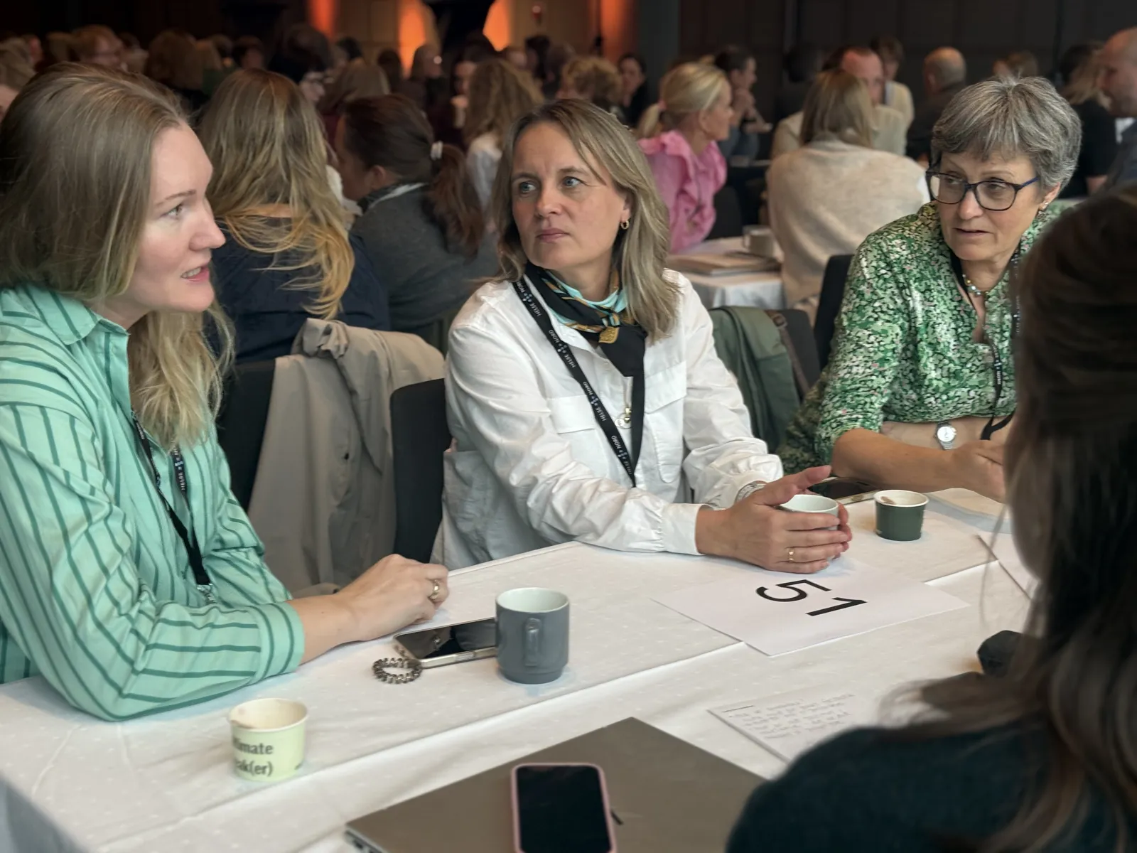 En gruppe kvinner som sitter ved et bord og spiller kort