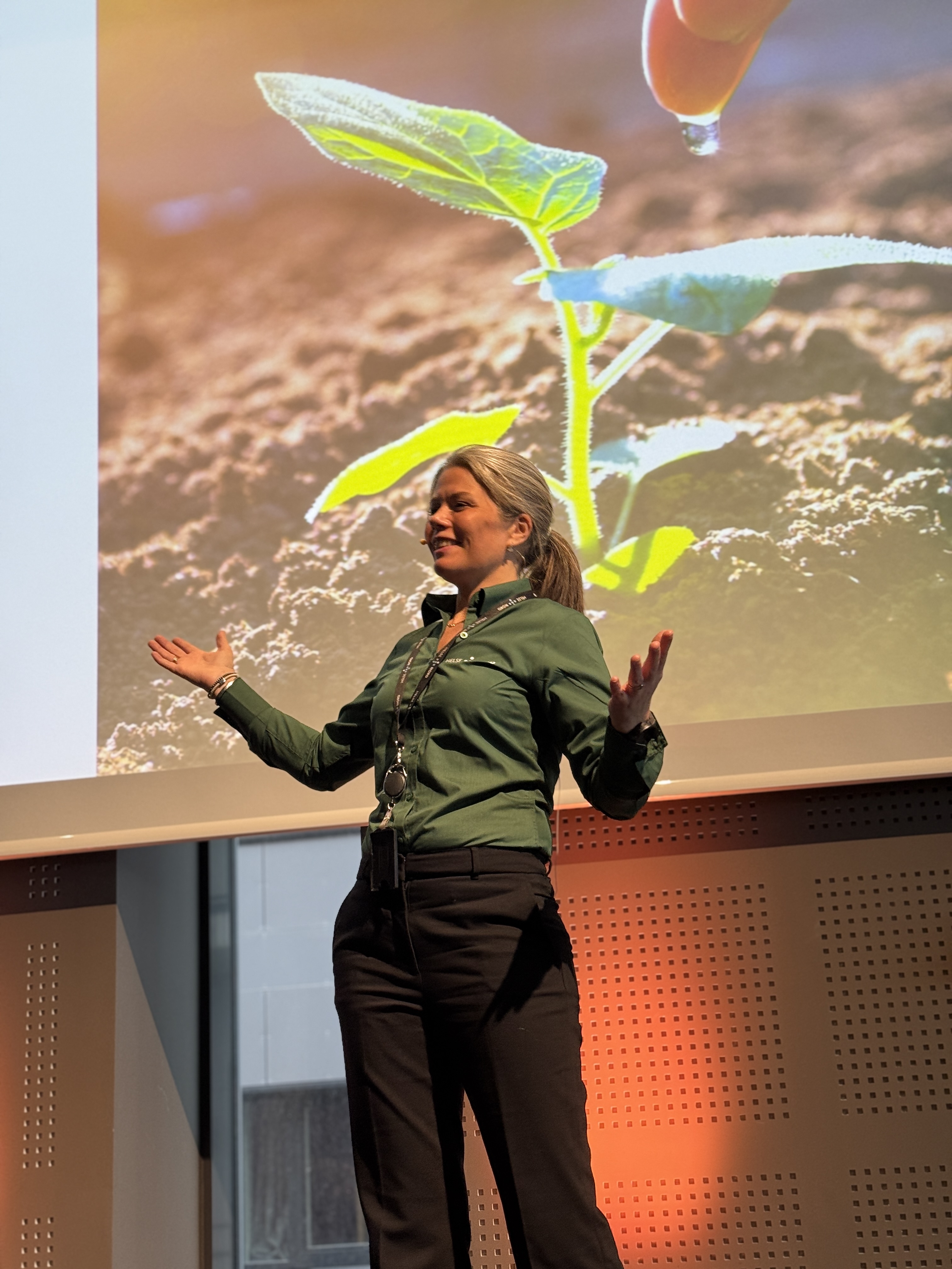 En person med lue og mikrofon med en stor fargerik fugl som flyr i luften