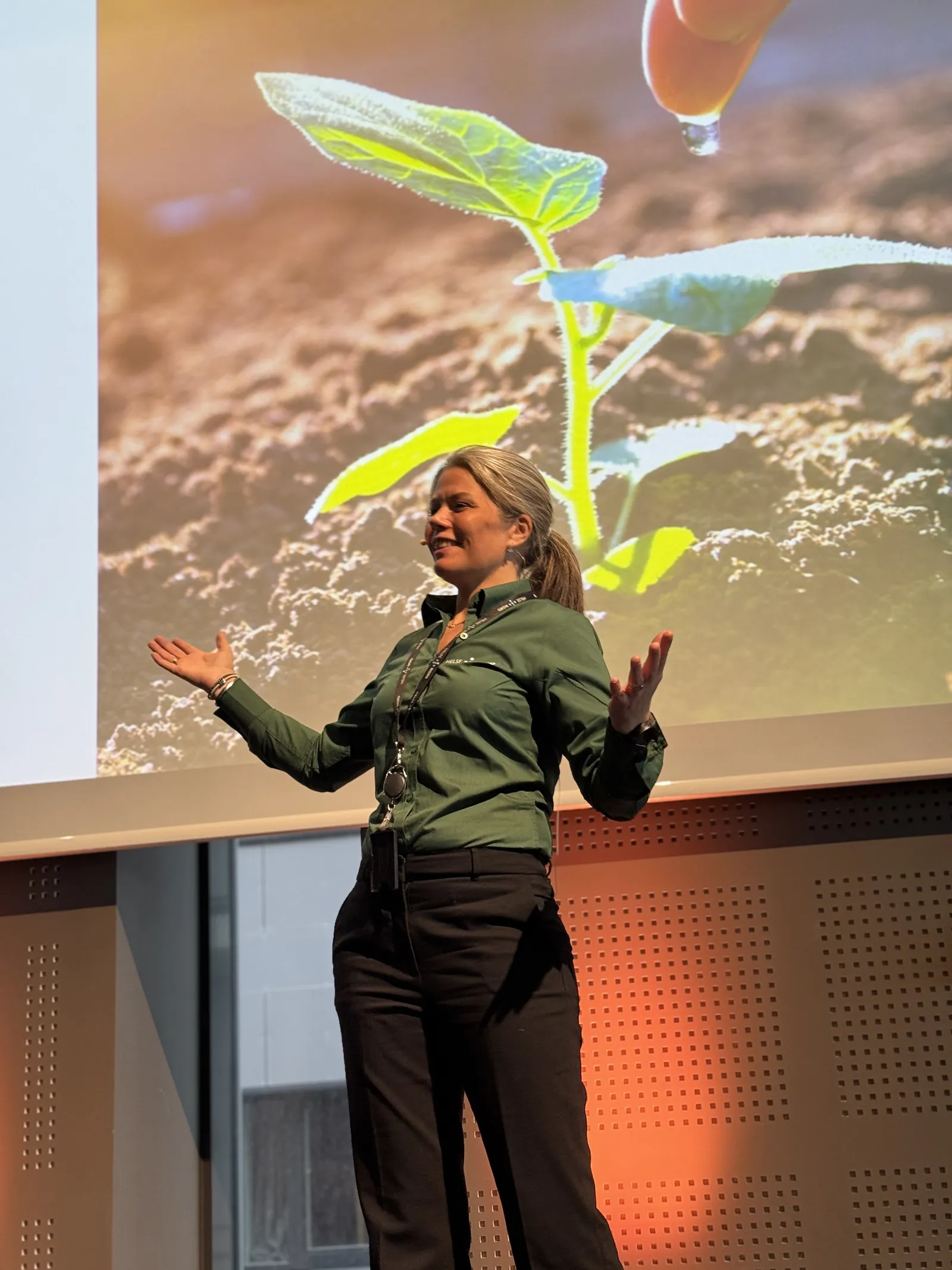En person med lue og mikrofon med en stor fargerik fugl som flyr i luften
