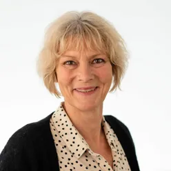 En kvinne som smiler til kameraet