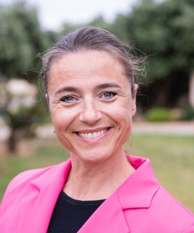 En kvinne som smiler til kameraet