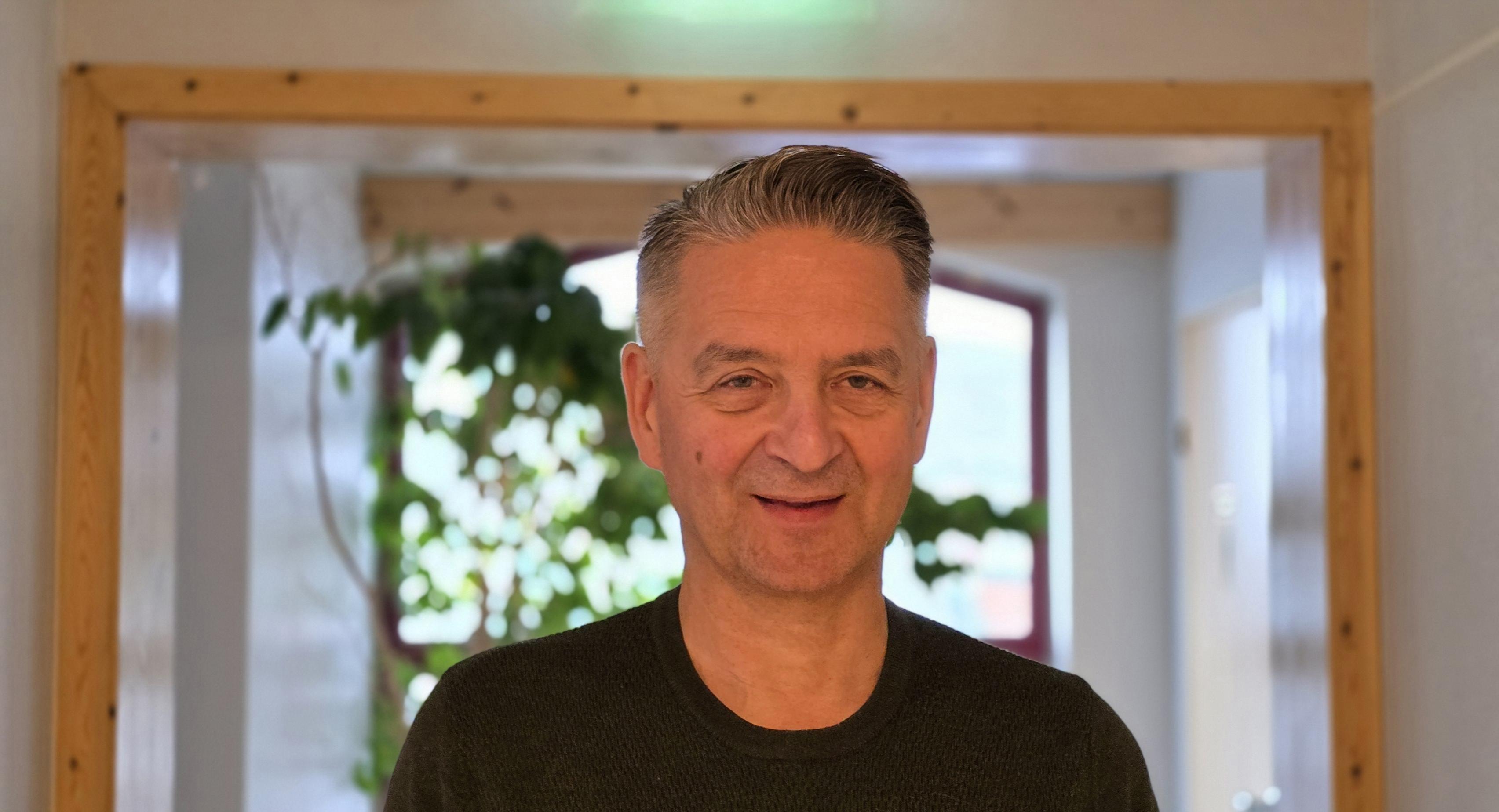 En mann som smiler til kameraet