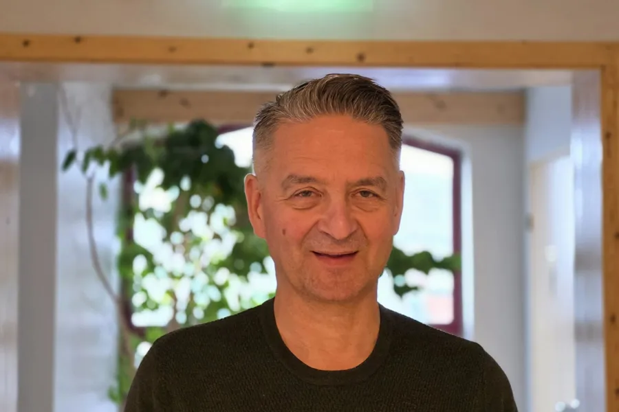 En mann som smiler til kameraet