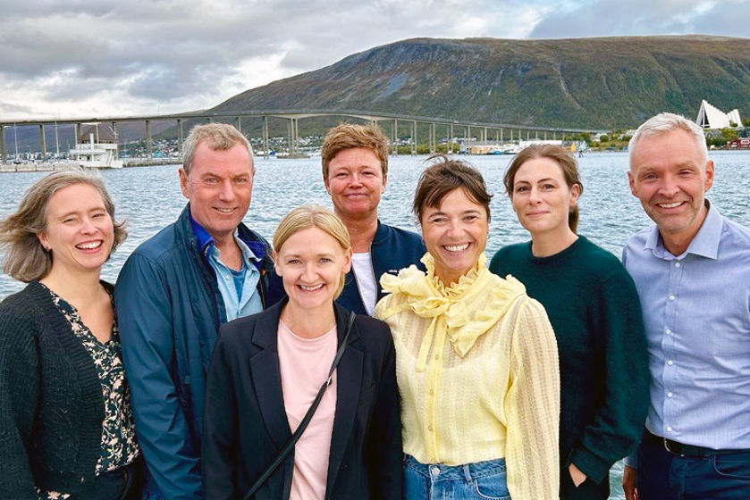 En gruppe mennesker som poserer for et bilde foran en vannmasse