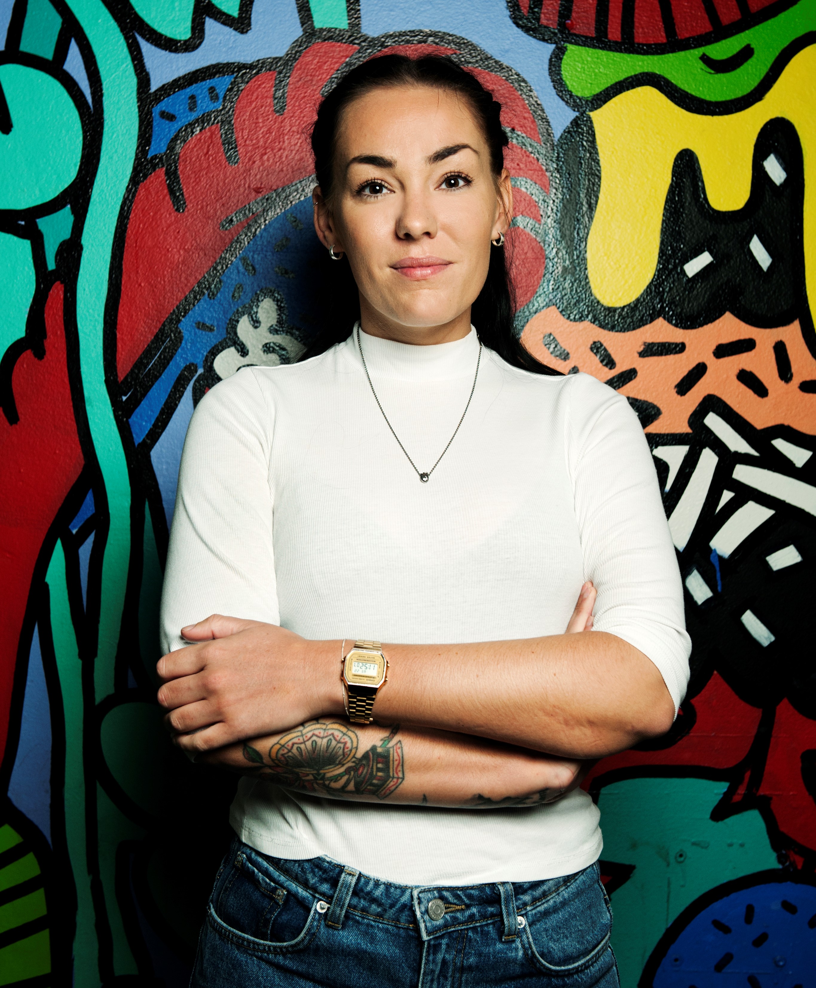 En kvinne foran en vegg med grafitti