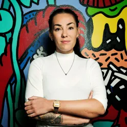 En kvinne foran en vegg med grafitti