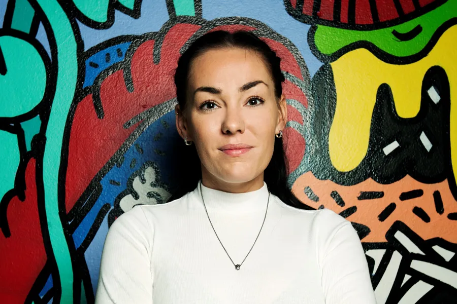 En kvinne foran en vegg med grafitti